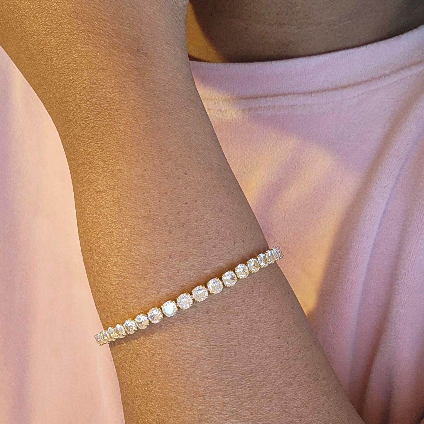 a woman's arm with a cz diamond tennis bracelet on it