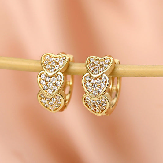 a pair of diamond heart earrings on a stick