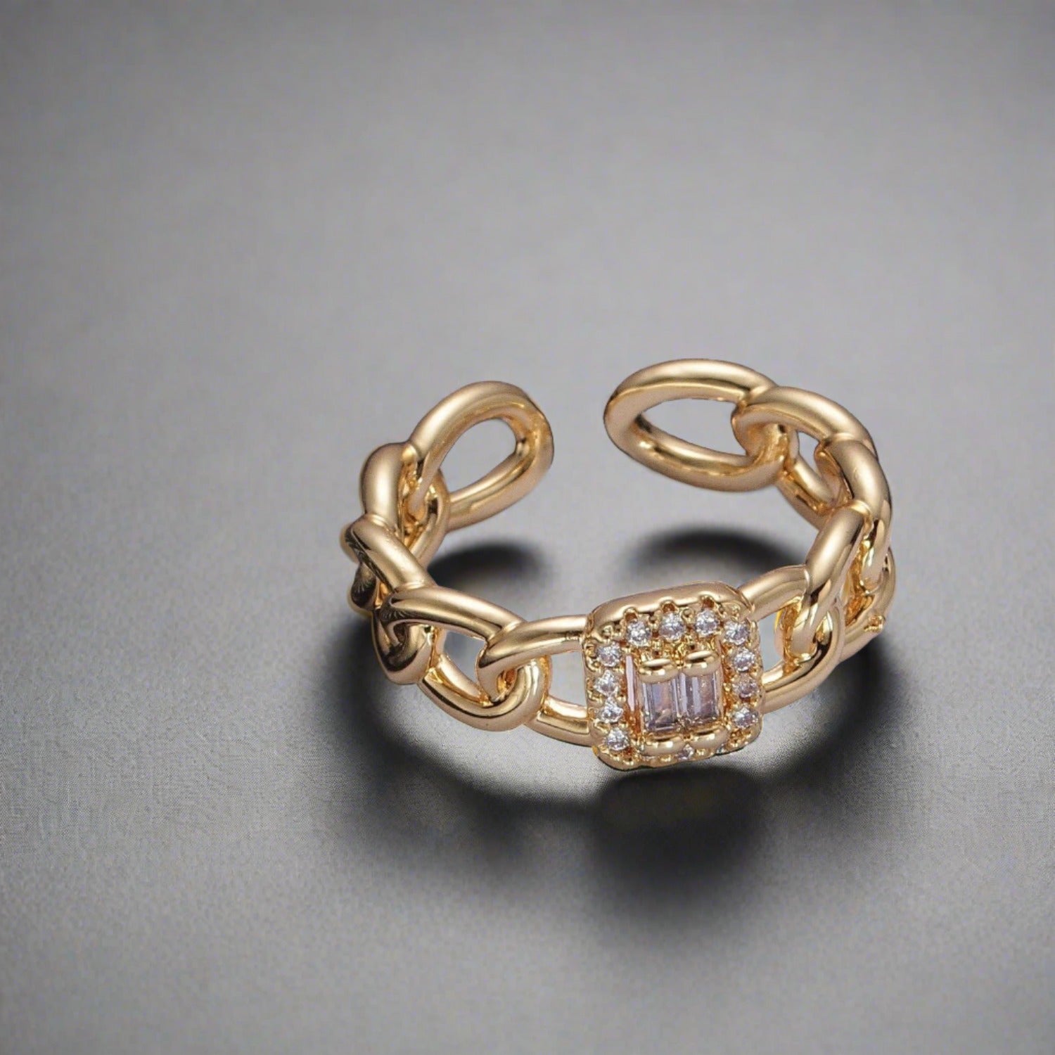 a gold open cuff ring sitting on top of a ruler