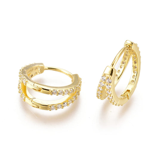 a pair of small gold earrings with clear stones on white background