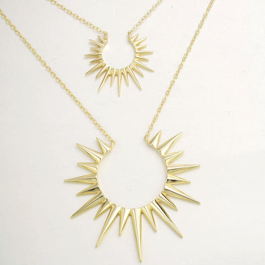 a pair of gold necklaces with spikes on them