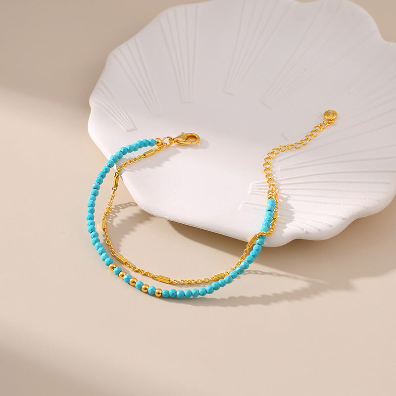 a blue beaded bracelet sitting on top of a white plate