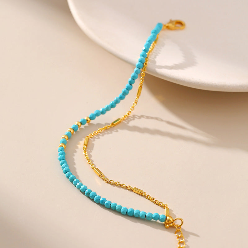 a white plate with a blue beaded bracelet on it