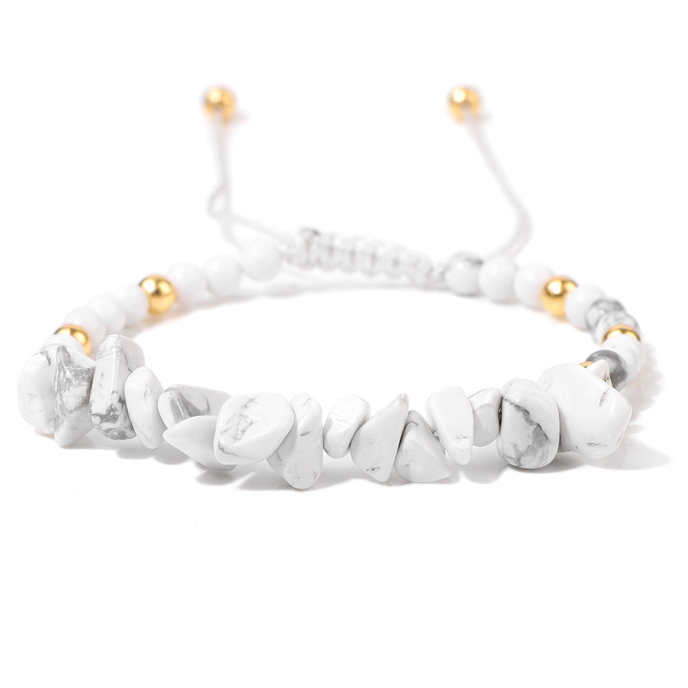 a white bracelet with gold beads on a white background