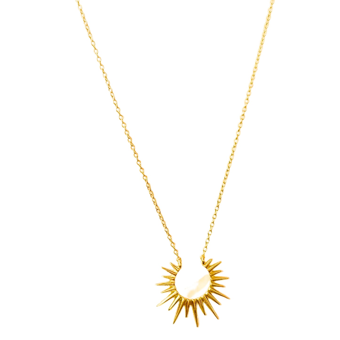 a gold necklace with a starburst on it