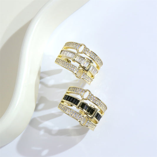 two gold rings with black and white stones