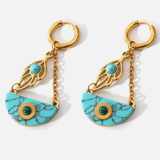 a pair of turquoise and gold earrings hanging from chains