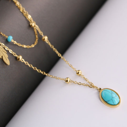 a close up of a necklace with a turquoise stone